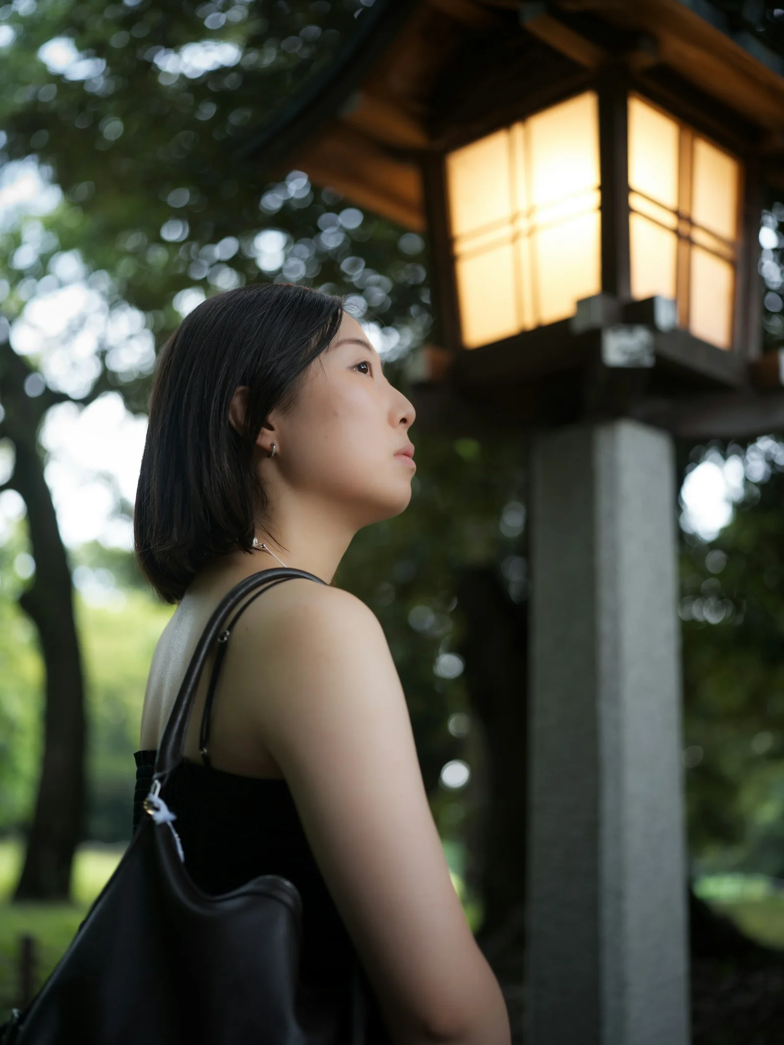 Woman looking at glowing traditional outdoor lantern