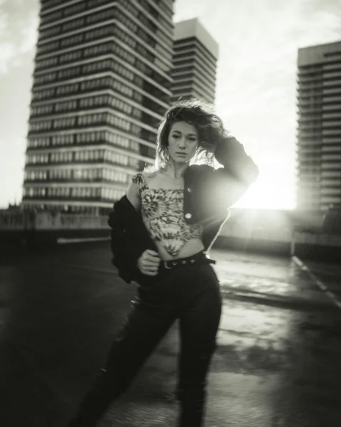 woman in black and white tank top and black pants standing on road
