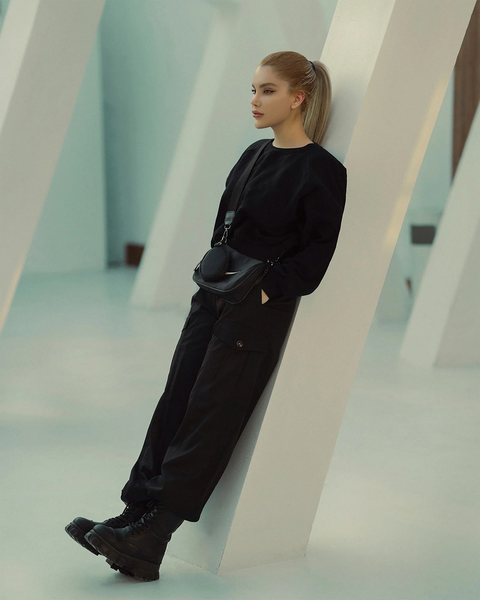 a woman leaning against a wall with her hands on her hips