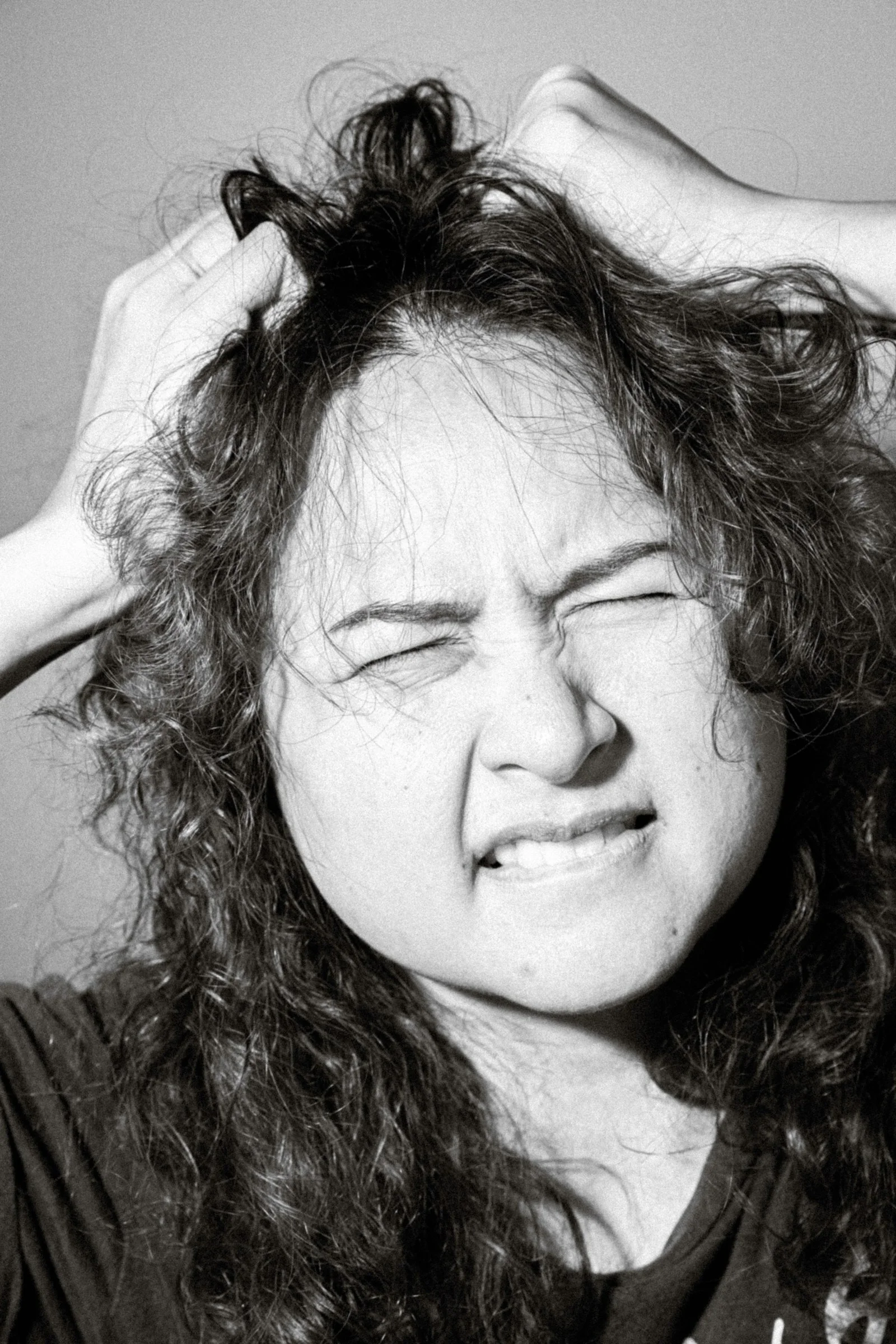 a black and white photo of a woman brushing her hair