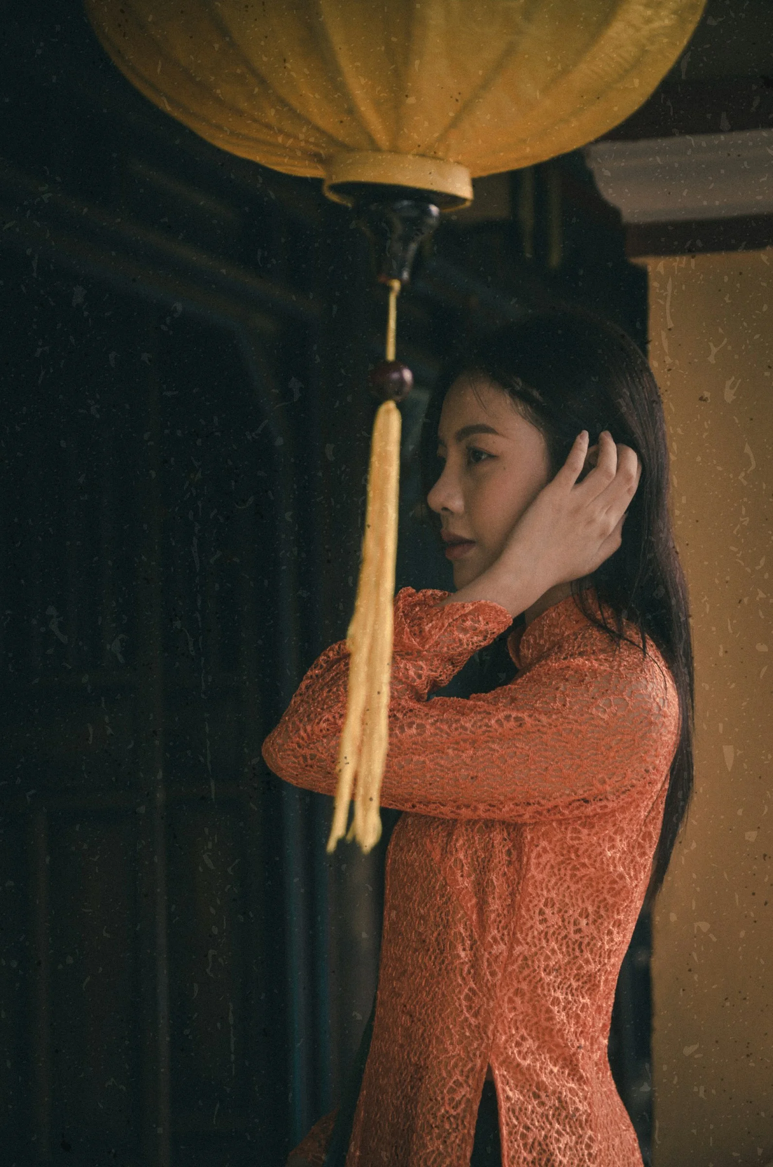 一個穿橙色連身裙的女人拿著黃色燈籠