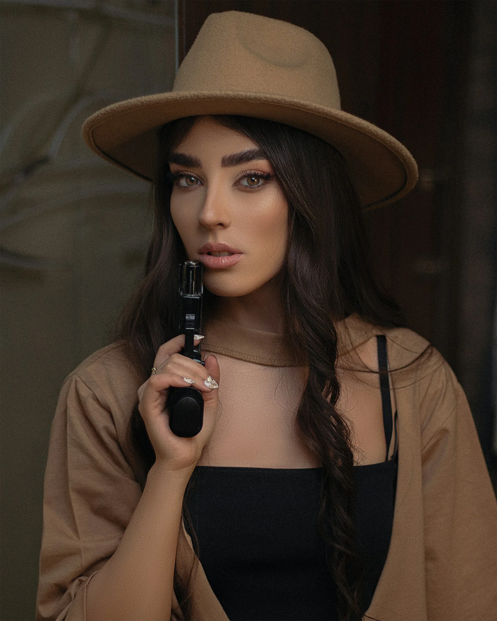 a woman wearing a brown hat holding a camera
