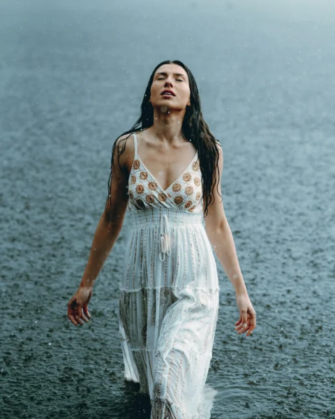 Woman enjoys the rain with arms outstretched