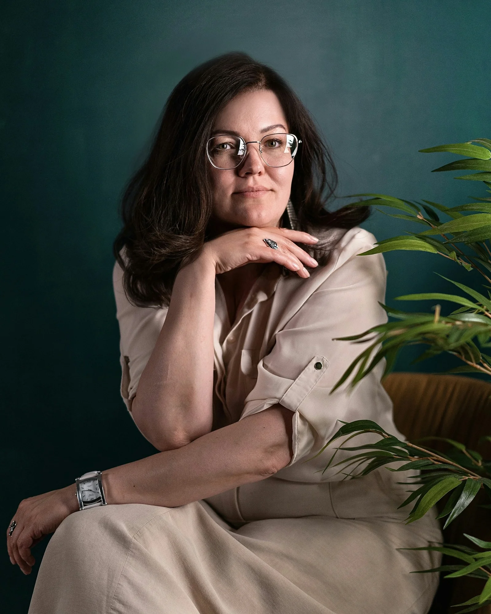 一名女子坐在椅子上,旁邊有一盆盆栽