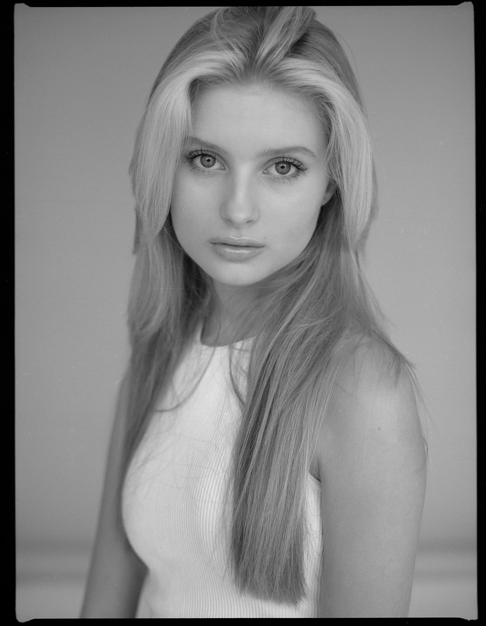 Young woman with long blonde hair looking directly forward