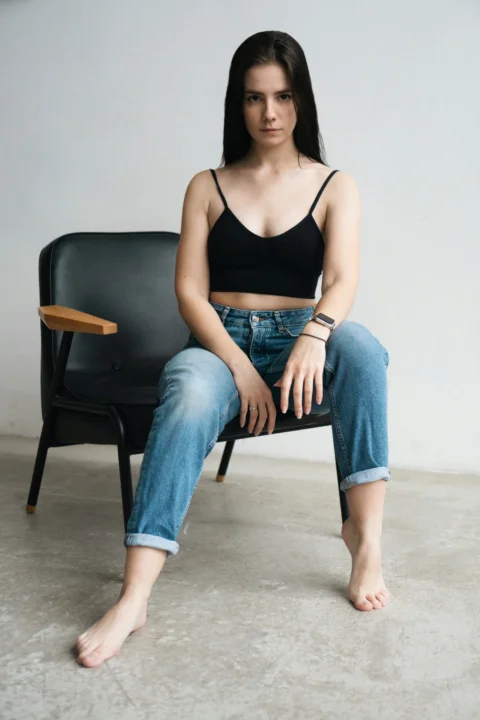a woman sitting on a chair with her legs crossed
