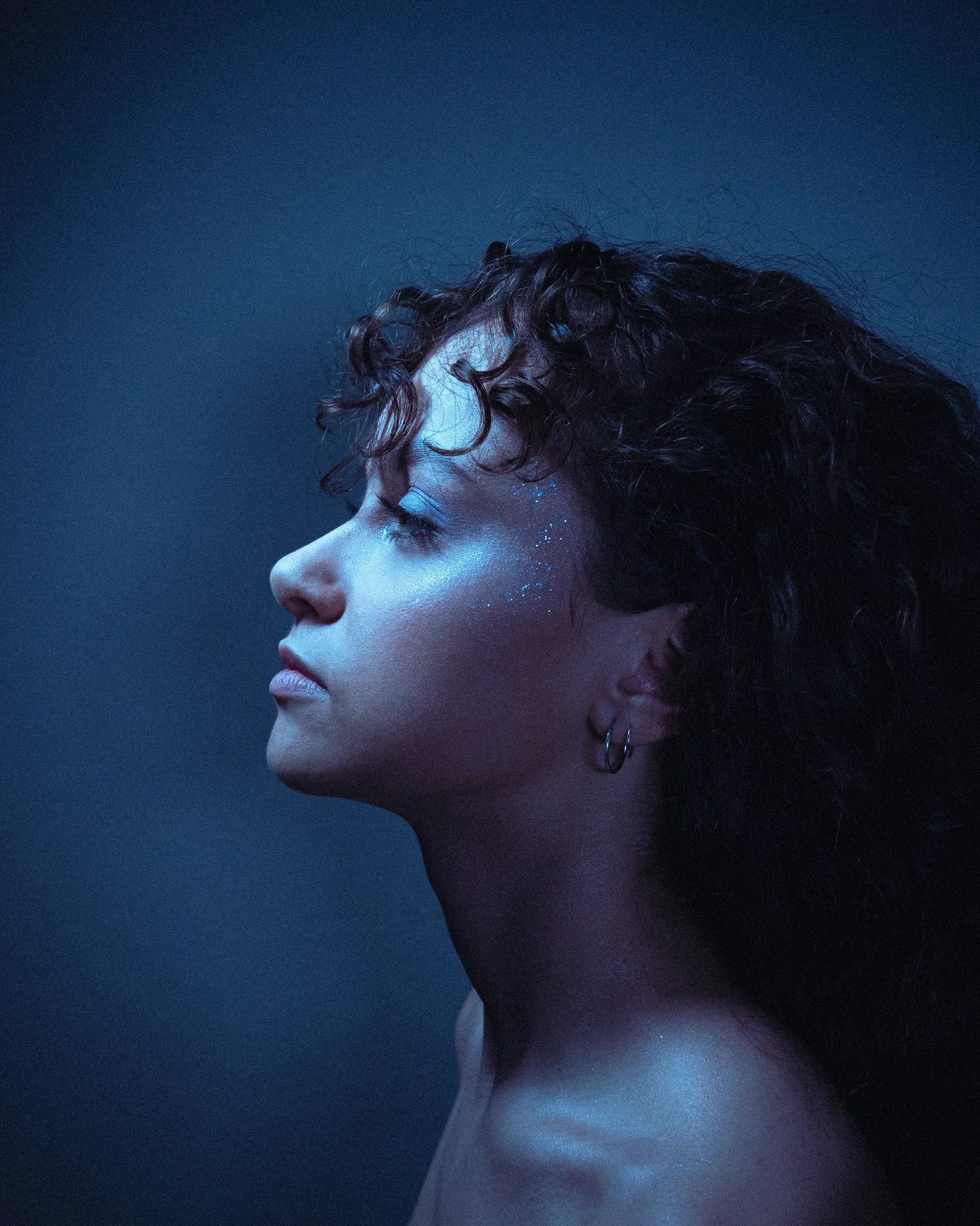 a woman with blue makeup and curly hair