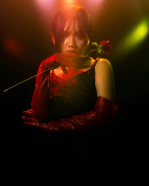 a woman in a red dress holding a rose