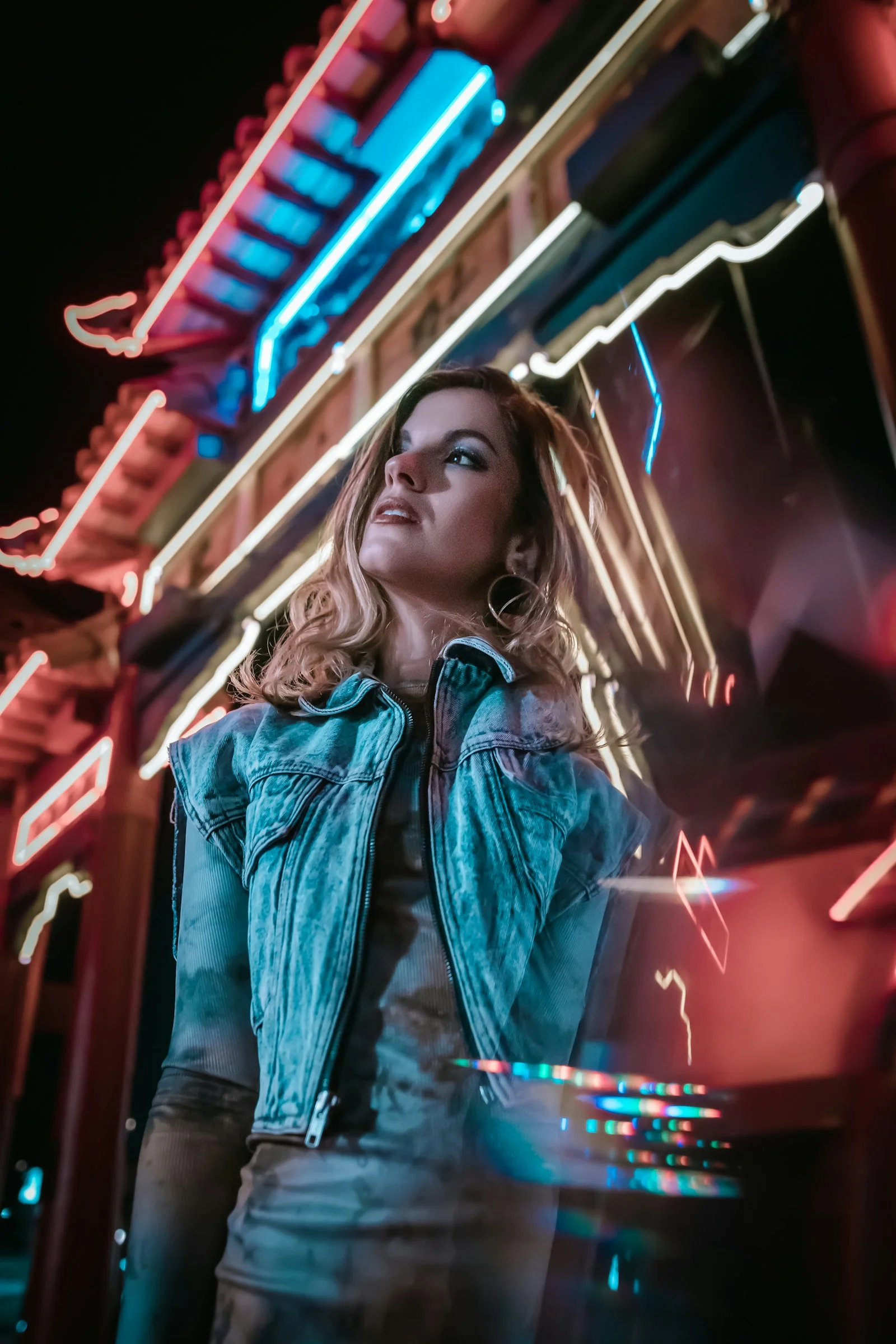 woman in blue denim jacket standing near glass window