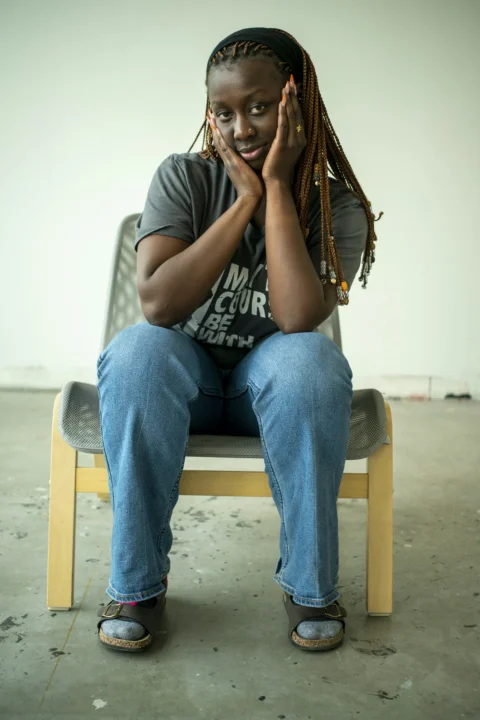 A woman sits posing in a chair