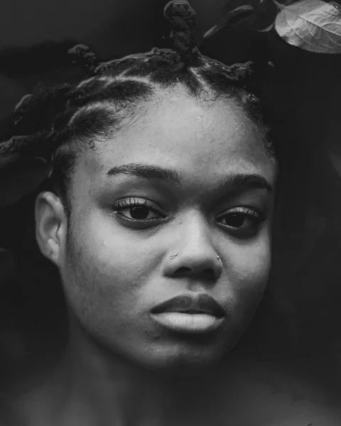 a black and white photo of a woman with braids