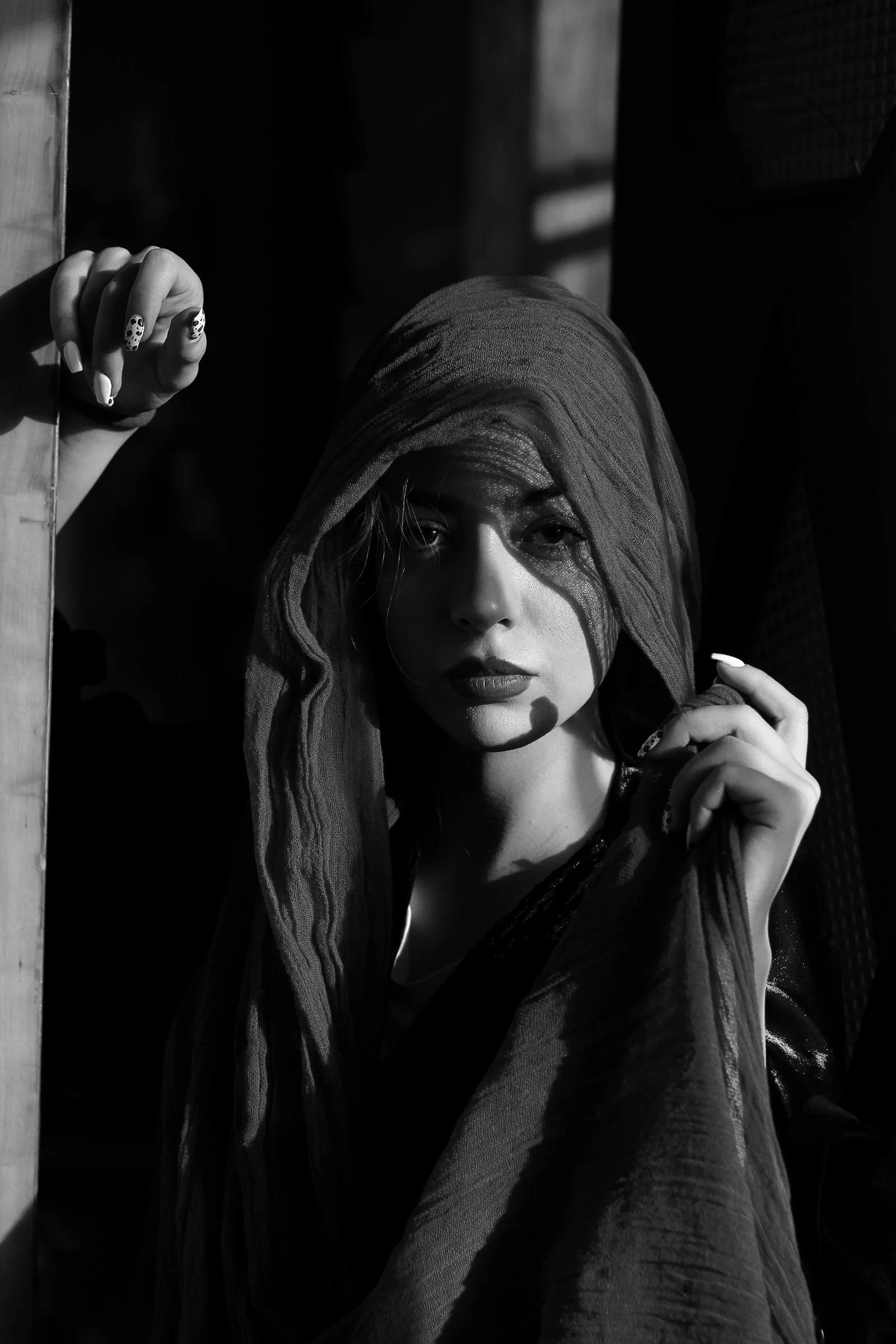 a black and white photo of a woman wearing a veil