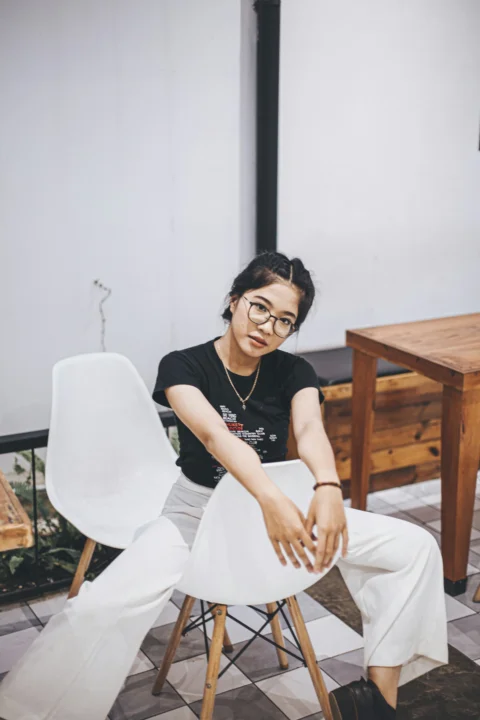 一名女子坐在白色椅子上