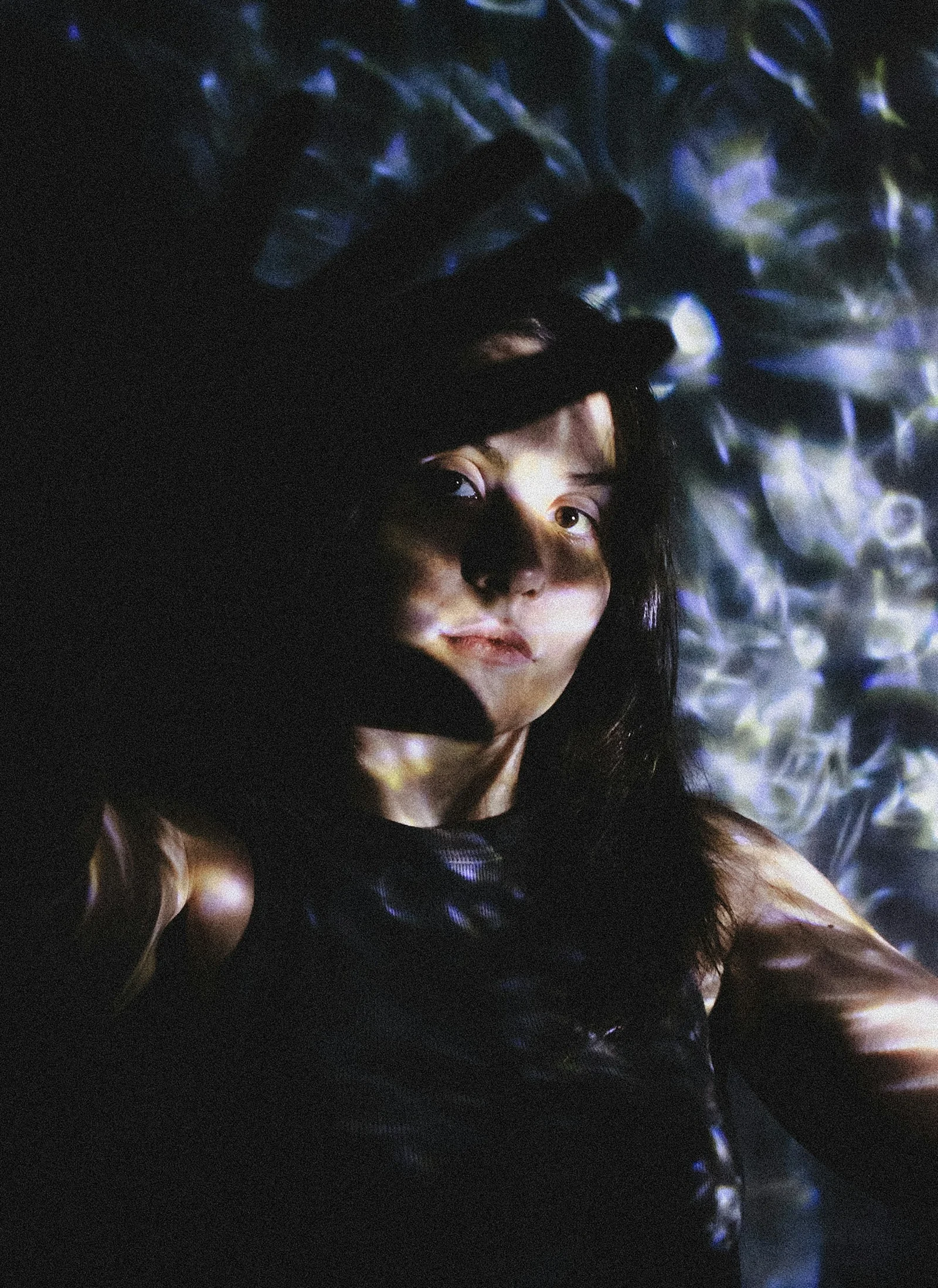 Woman's face illuminated by abstract light patterns