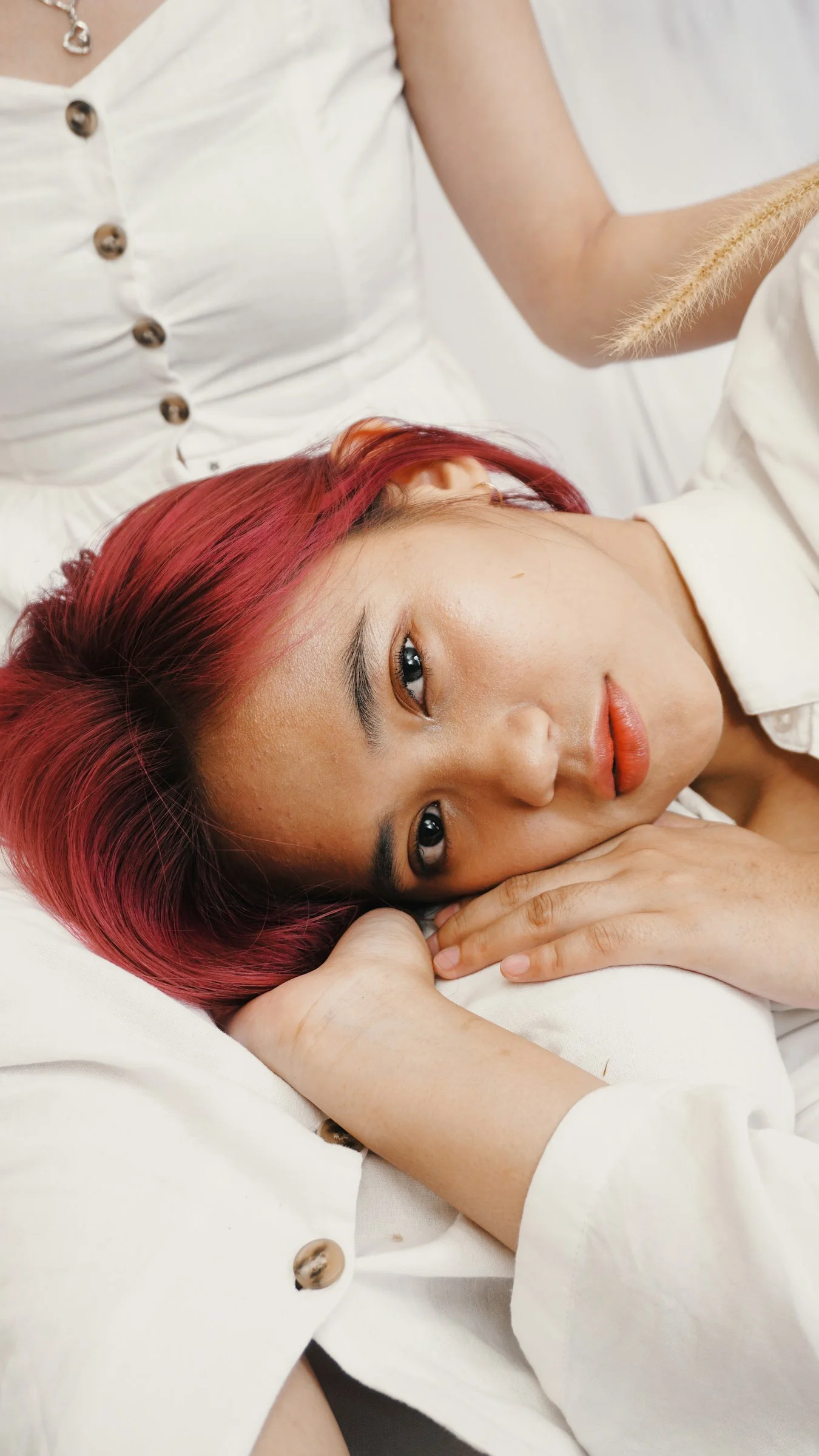흰 드레스 셔츠를 입고 침대에 누워 있는 여성