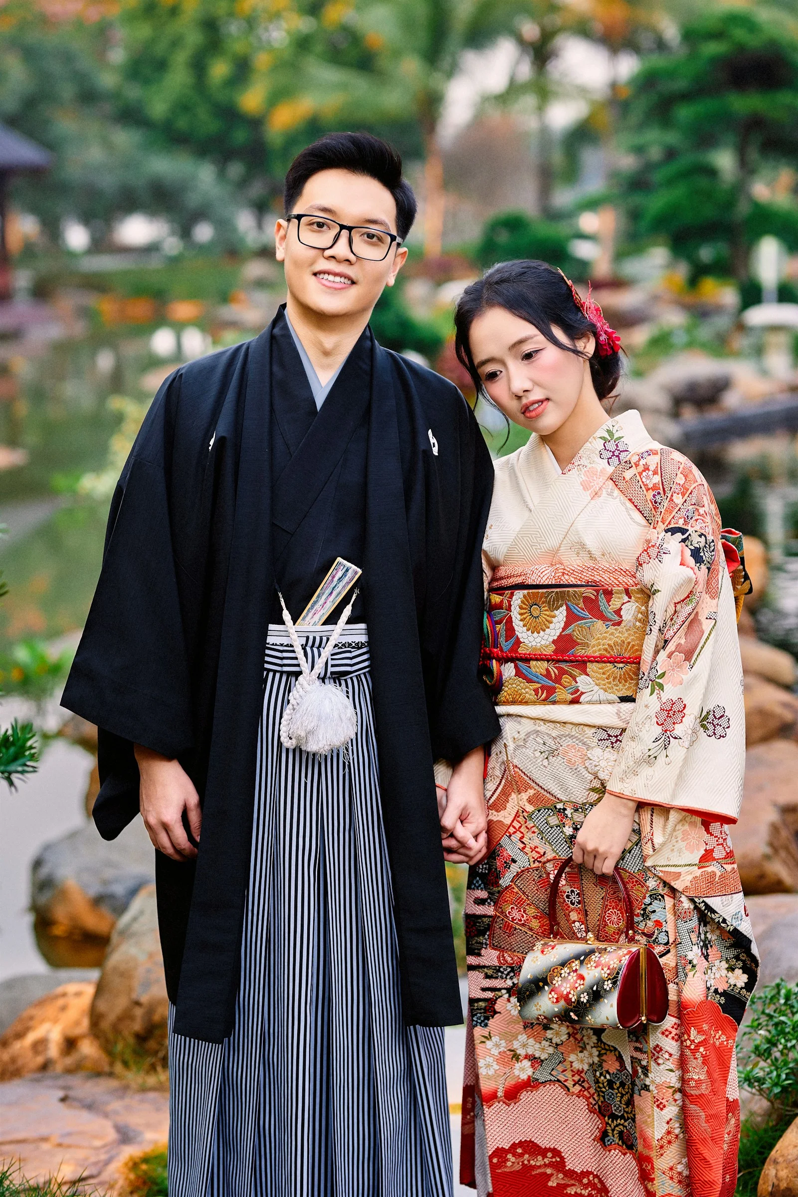 A couple in traditional japanese kimonos standing in a garden