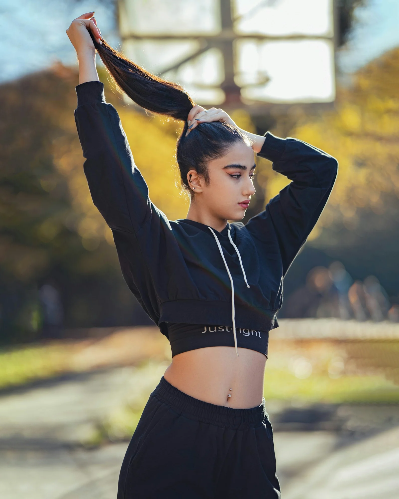 A young woman puts her hair up