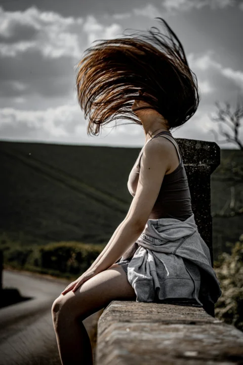 Woman with long hair flipping outdoors