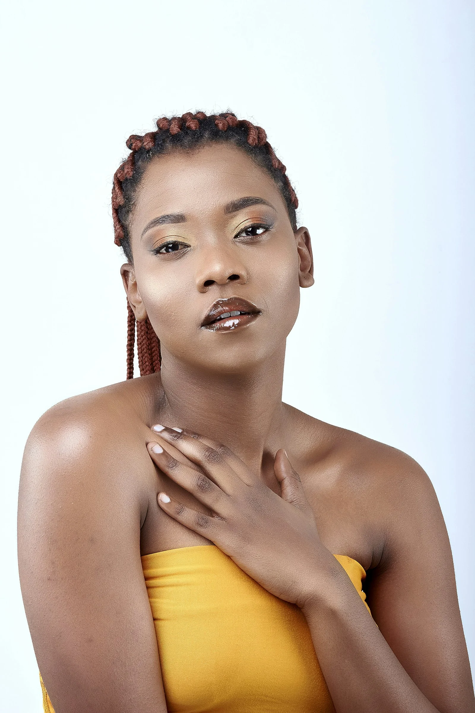 a woman in a yellow top with her hands on her chest