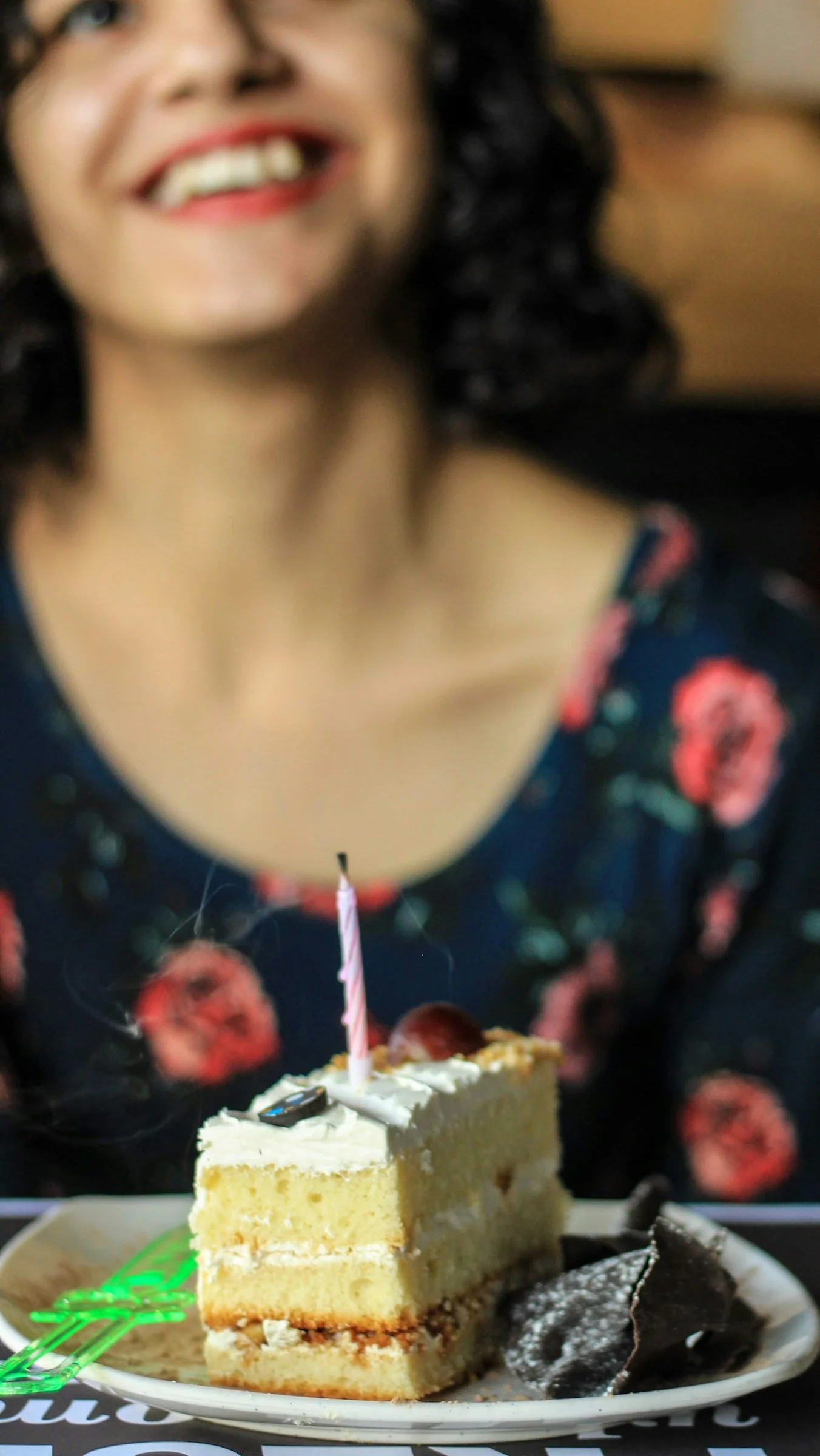 A woman sitting at a table with a piece of cake