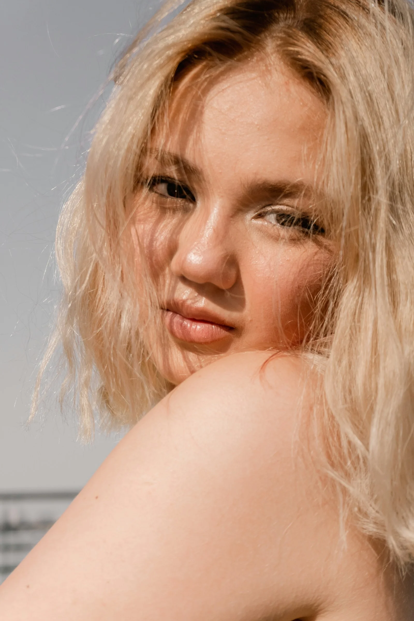 A woman with blonde hair looking over her shoulder in warm sunlight