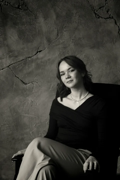 Woman in black top sitting in armchair