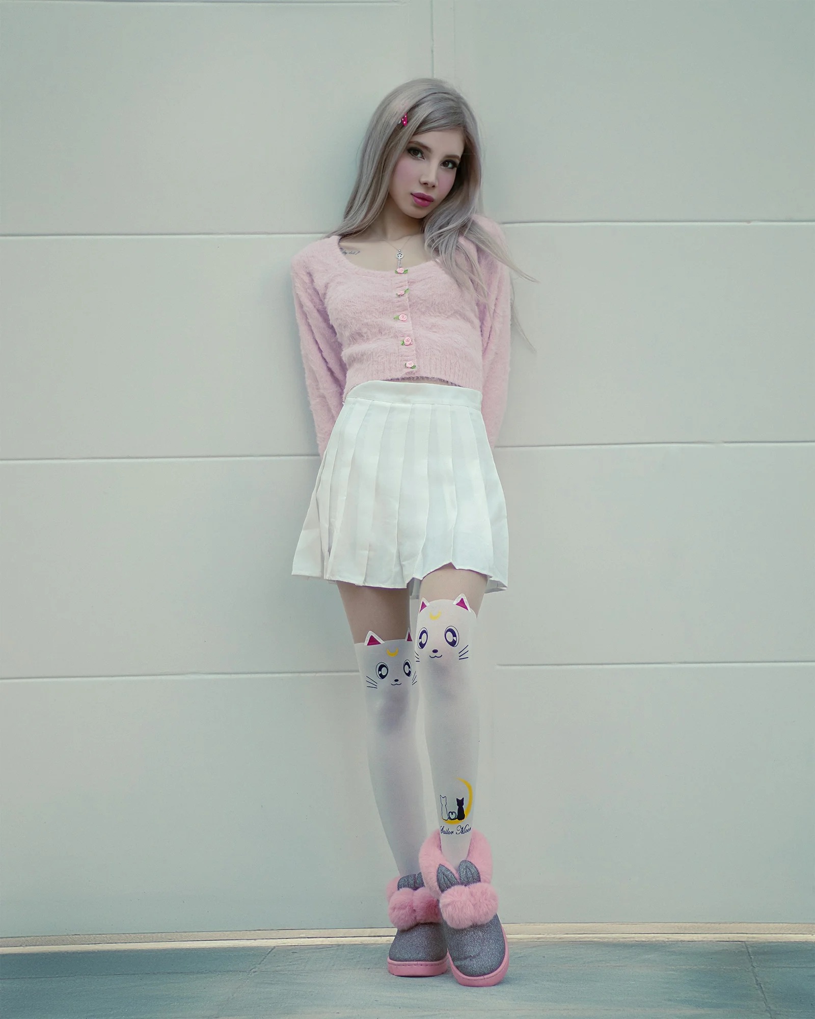 ピンクのセーターと白いスカートを着たグレー髪の女の子
