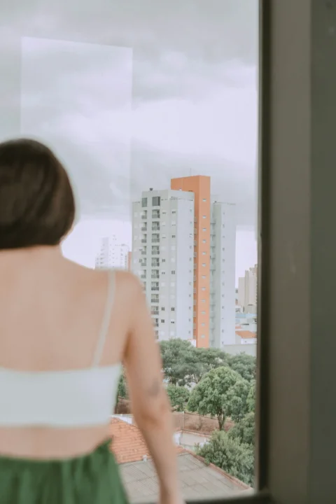 一个女人从窗户眺望城市