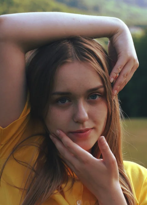 Young woman with long blonde hair in yellow shirt