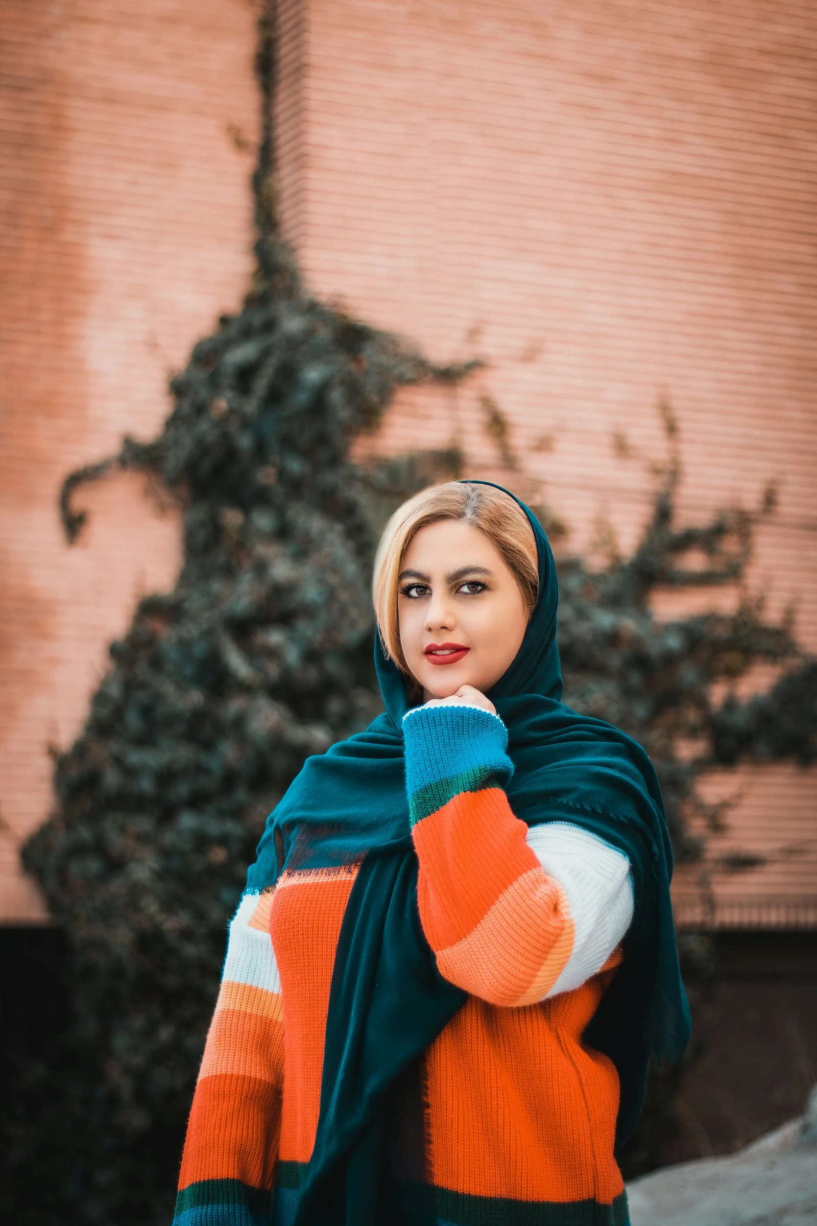 woman in red and white scarf standing near brown concrete building during daytime