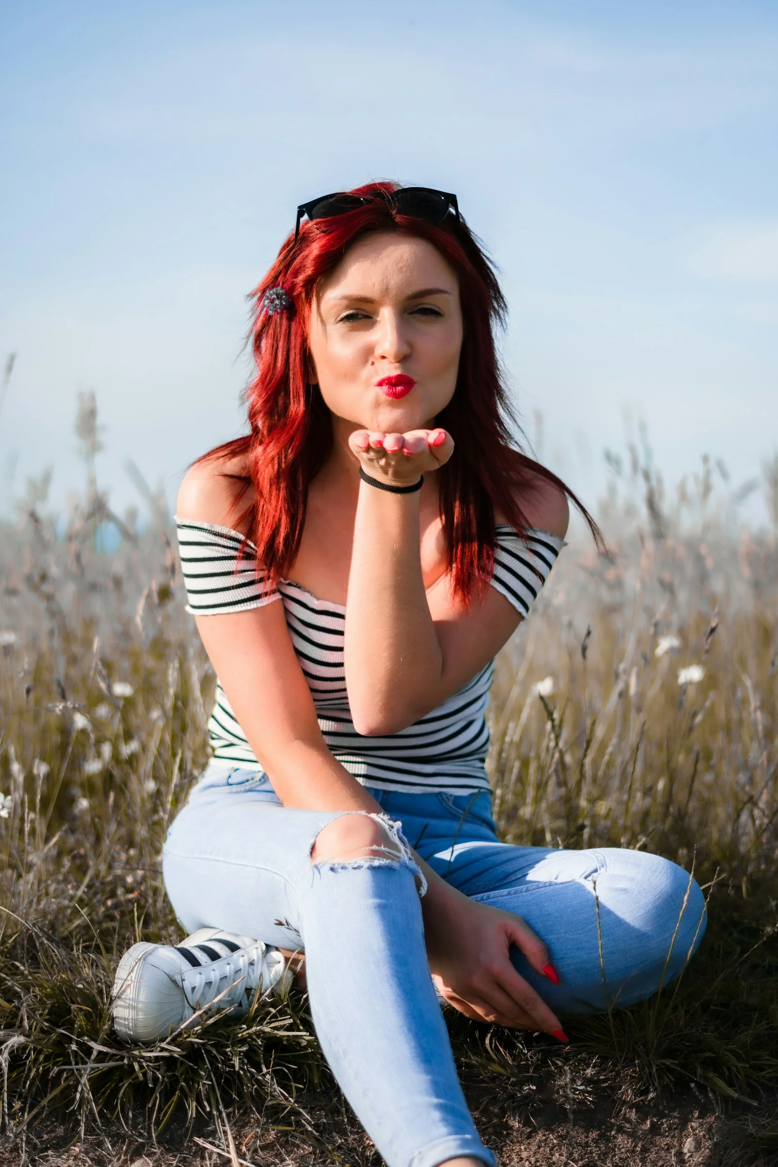 a woman with red hair sitting on the ground