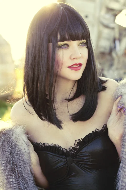 a woman in a black dress and fur coat