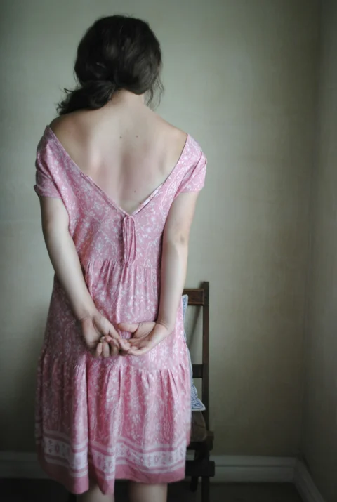 분홍 민소매 드레스를 입은 여성