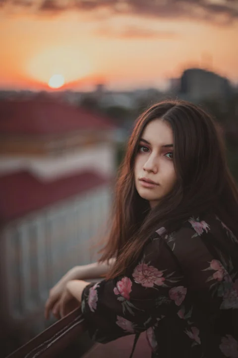a woman with long hair standing on a balcony