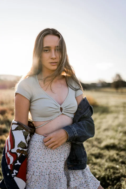 a woman in a dress is standing in a field