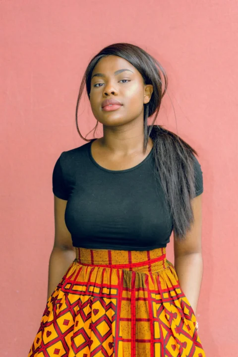woman wearing black shirt standing in front of red wall