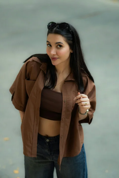 A young woman in a brown shirt and jeans
