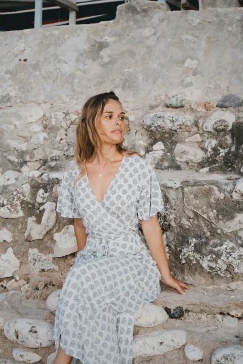 A woman is sitting on a stone wall