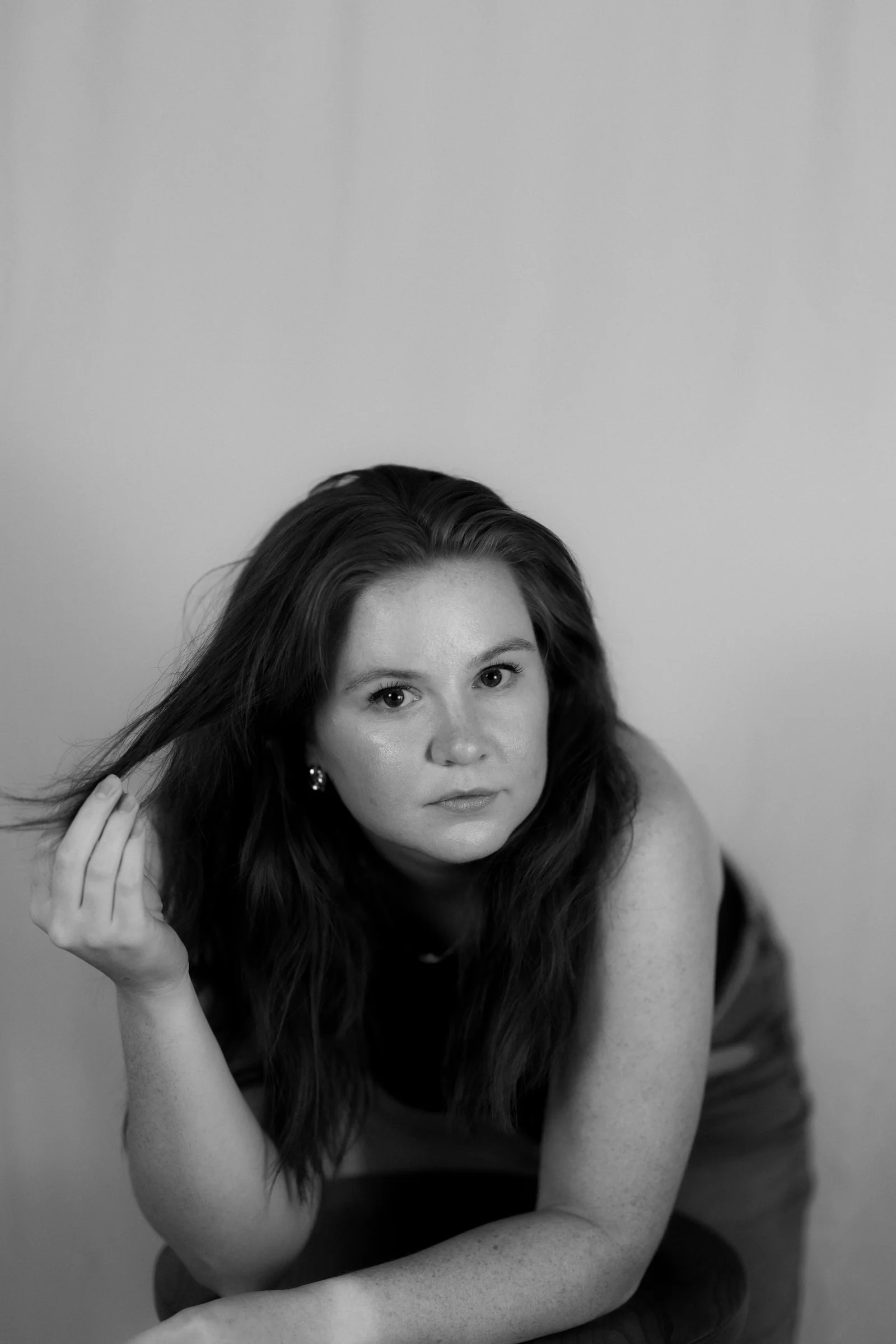A woman with long hair tilts her head slightly