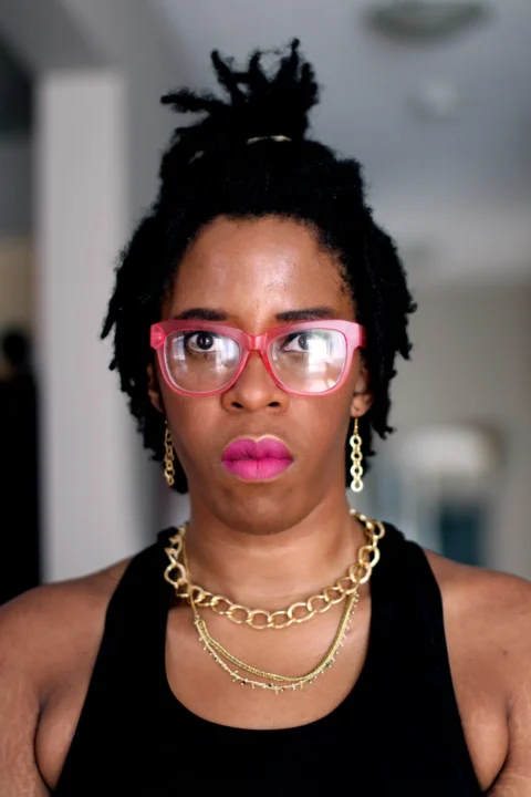 woman in black tank top wearing red framed eyeglasses