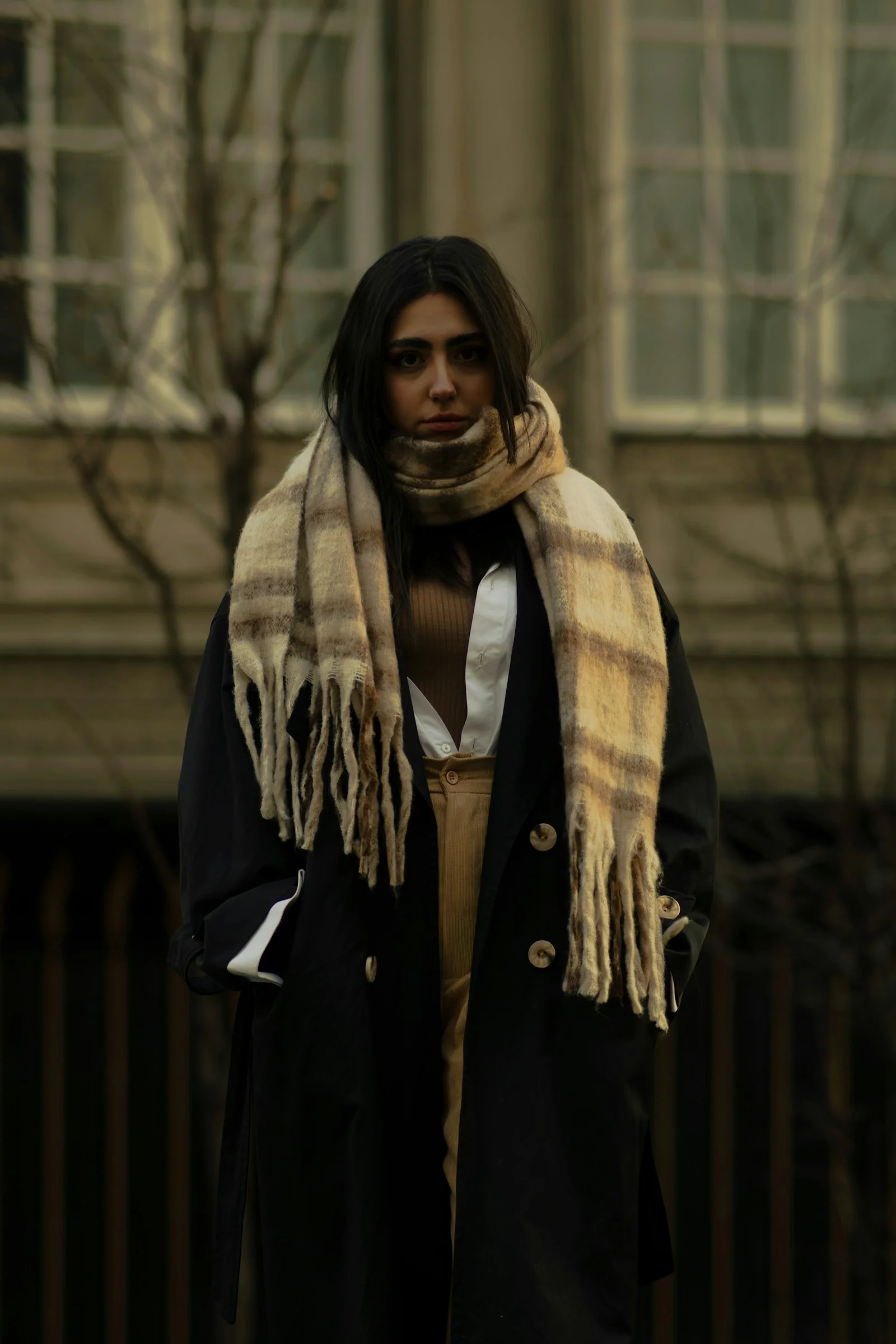 A woman walking down a street wearing a scarf
