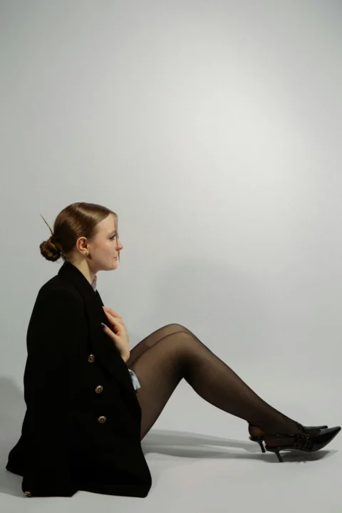 A woman poses in black attire, eyes forward