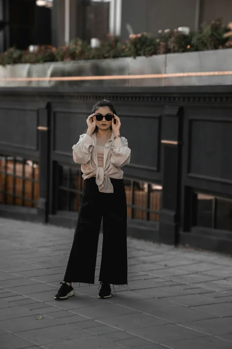 A woman standing on a sidewalk talking on a cell phone
