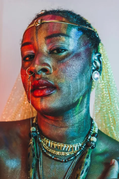 Woman with rainbow face paint and glitter
