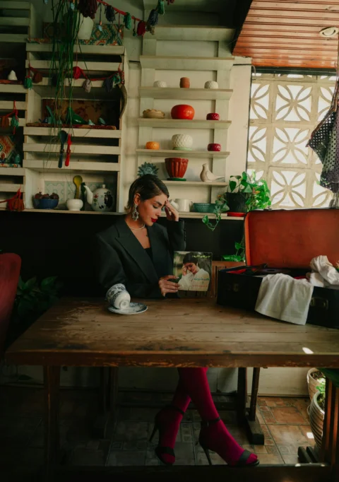 A woman sits and reflects at a wooden table