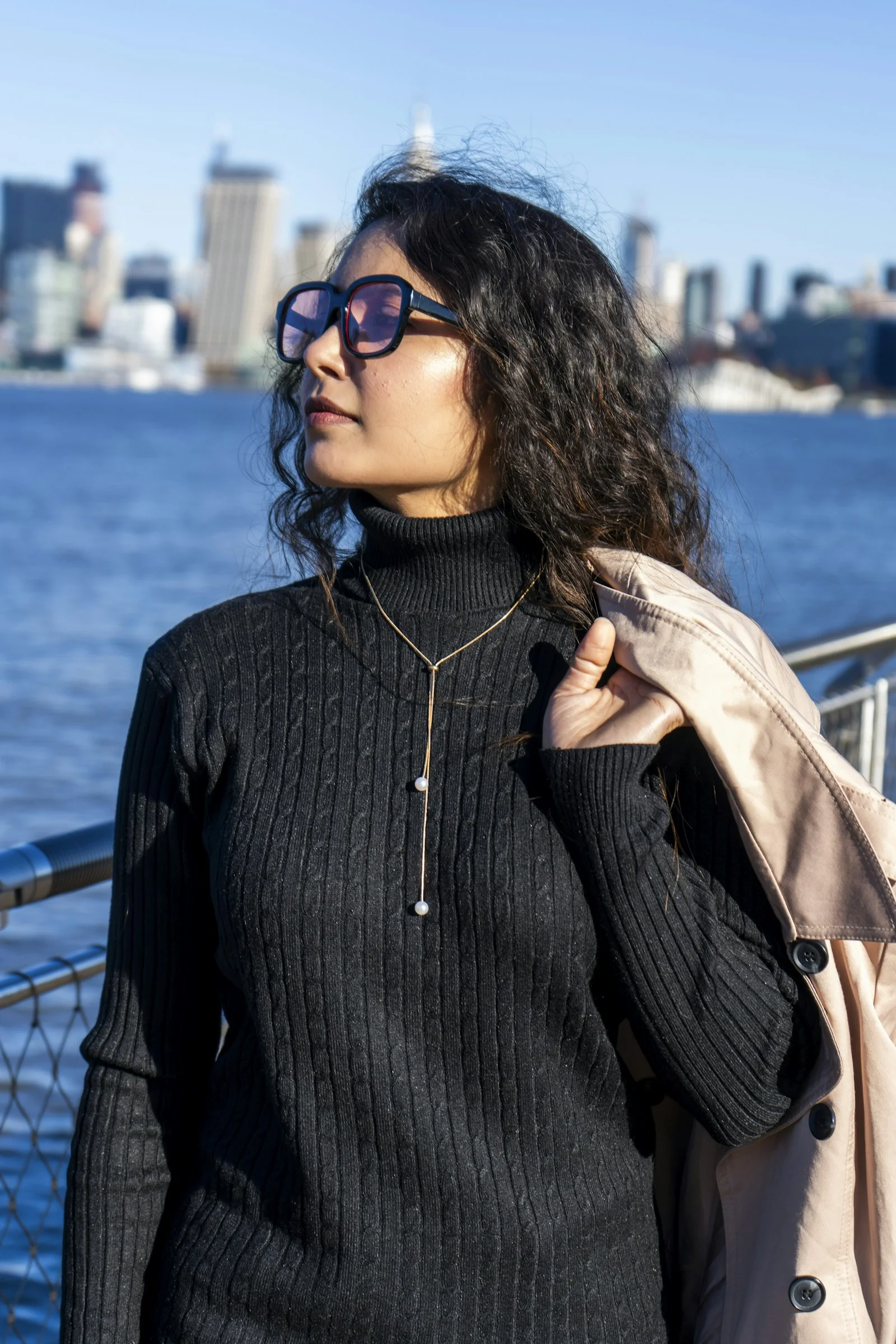 a woman wearing sunglasses and a black turtle neck sweater