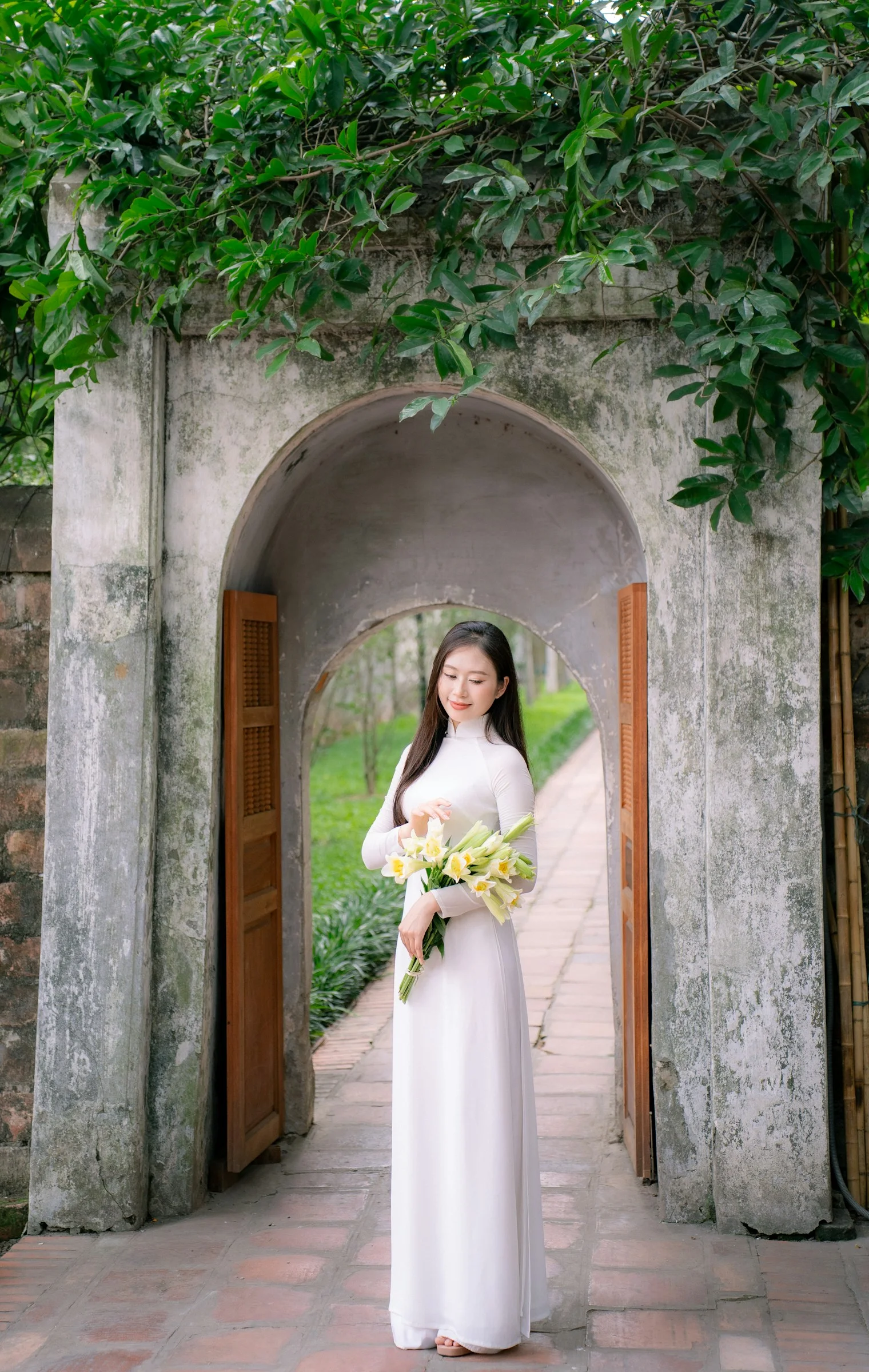 一位白衣女士站在拱门下