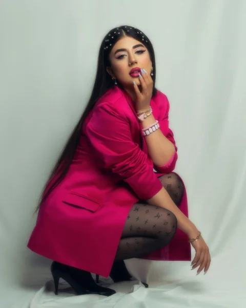一位穿粉色外套的女人正在摆姿势拍照