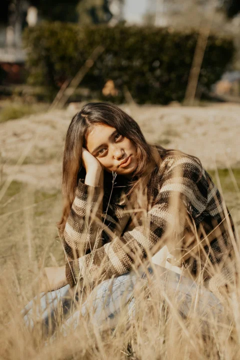 A woman sitting in a field of tall grass
