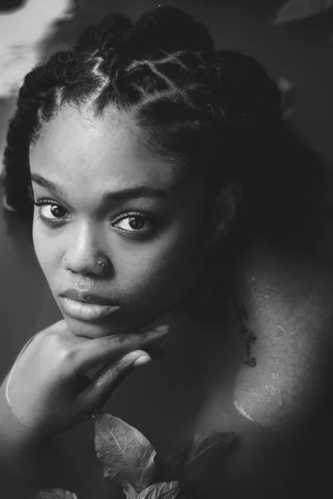 a black and white photo of a woman with braids